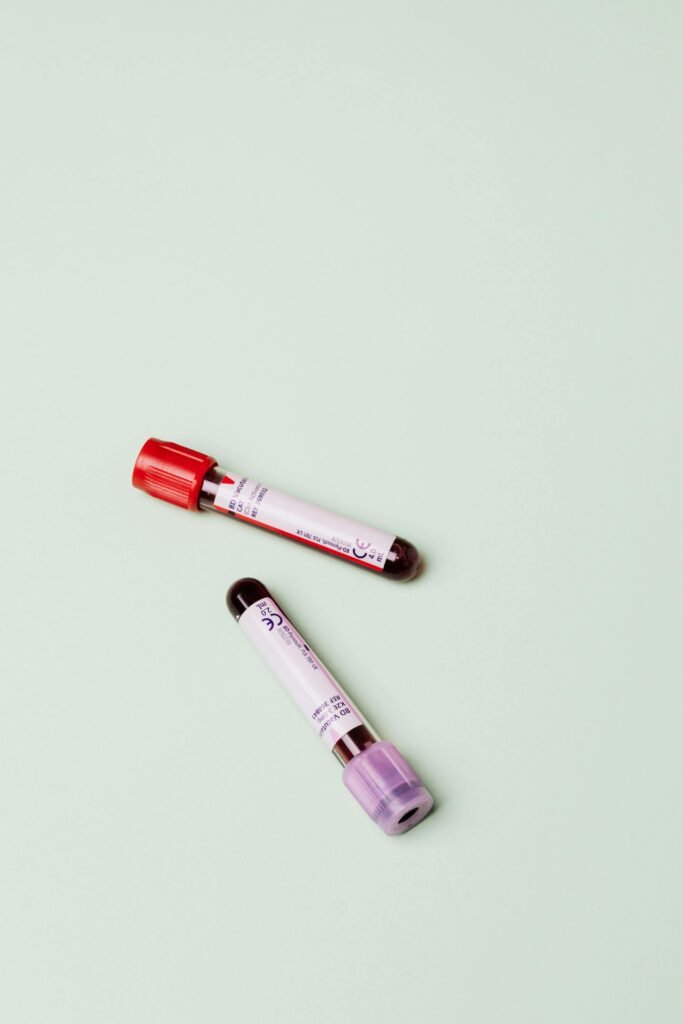 pexels-photo-4047151-4047151 Two blood test tubes displayed on a pastel green background, ideal for medical themes.
